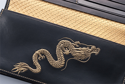 右肩上がり昇龍財布は龍の鱗の如くゴールドに輝く蛇革と昇龍がお財布を際立たせています
